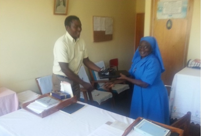 Picture of Mr Vincent Shaba, Health Desk Officer, hands over a laptop computer