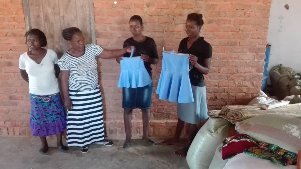 Young people displaying dresses they have made