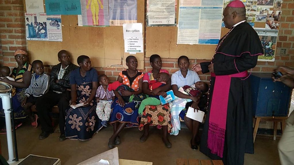 Bishop Mtumbuka interacting with beneficiaries of health services offered by Kaseye Community Hospital