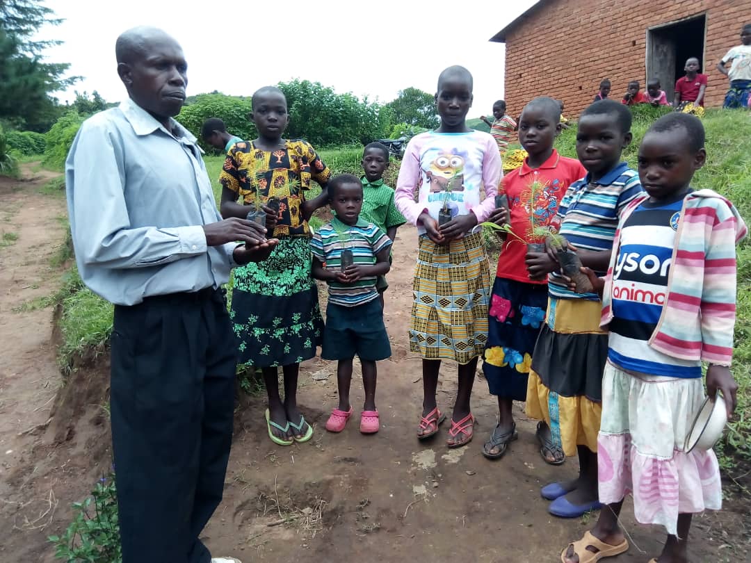 Sunday school children holding tree seedlings ready to plant