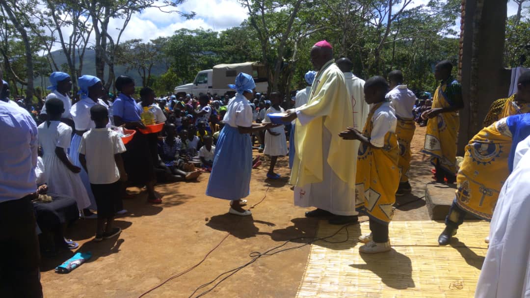 Bishop Mtumbuka receiving offerings from Christians