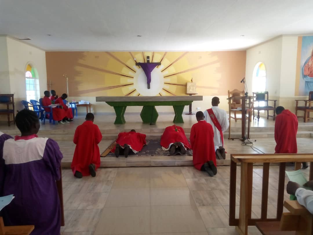 The Bishop and Father Silwamba prostrate before the cross in the sanctuary at the beginning of the liturgy in the cathedral