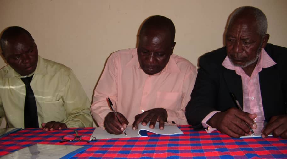 Mwangonde (C) signing the document while TA Kilupula (R) looks on - Picture by Jordan Simeon-Phiri