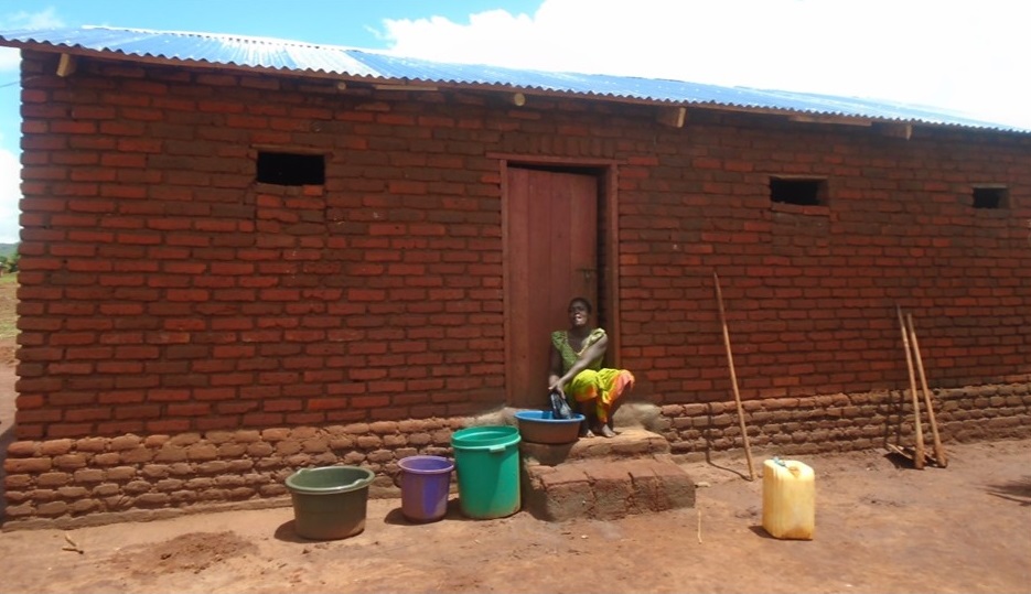 Tiness Silumba at her house constructed using money realised from village savings and loan.
