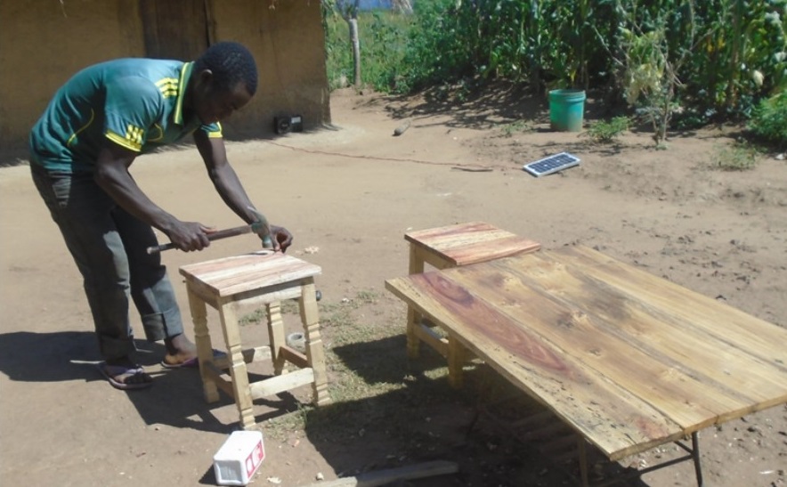 Jimu Msukwa at his carpentry shop early this year making final touches on his products