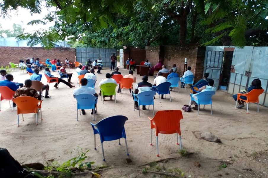 Curia staff at Bwiba practice social distancing during weekly update meetings that include reminders on Covid-19 preventive measures