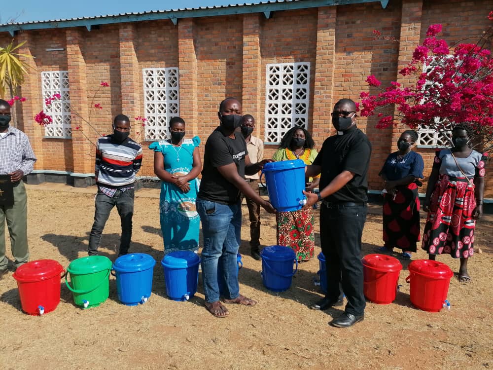 Father Mwenegamba (R) handing over some of the items to Catechetical Methodology Advisor, Paul Mwandira