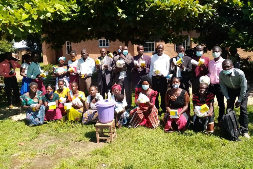 Happy instructors have a group photograph displaying gifts that they received as donated by the Coppel Family