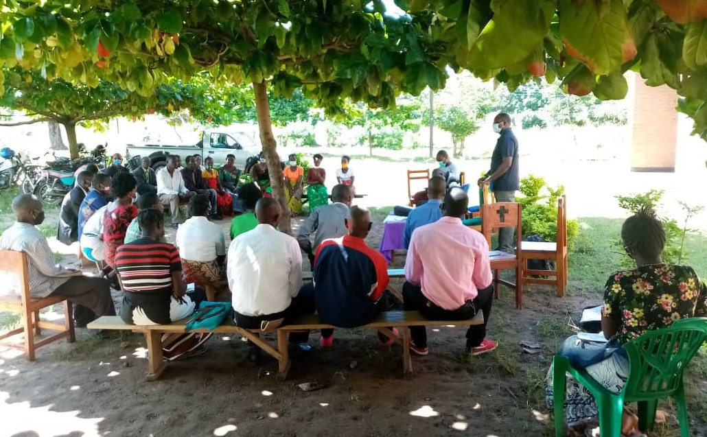 Participants receiving instructions from Father Joseph Sikwese (standing)