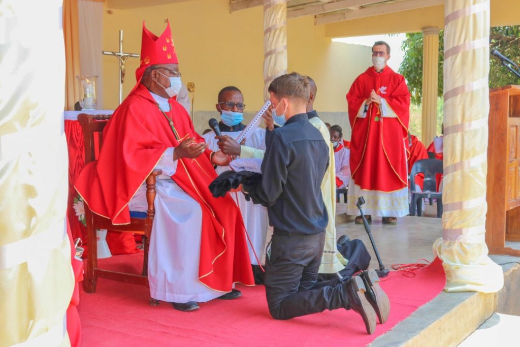 Bishop Mtumbuka blessing Jeremias and his official religious attire as Fr Federico (standing) who is Father Superior of the Society of St Elijah in the Diocese looks on