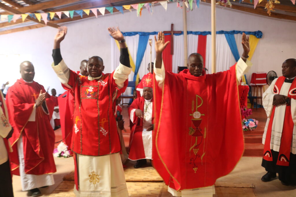 Newly ordained priest (in chasuble) and deacon (in dalmatic) immediately after their ordination